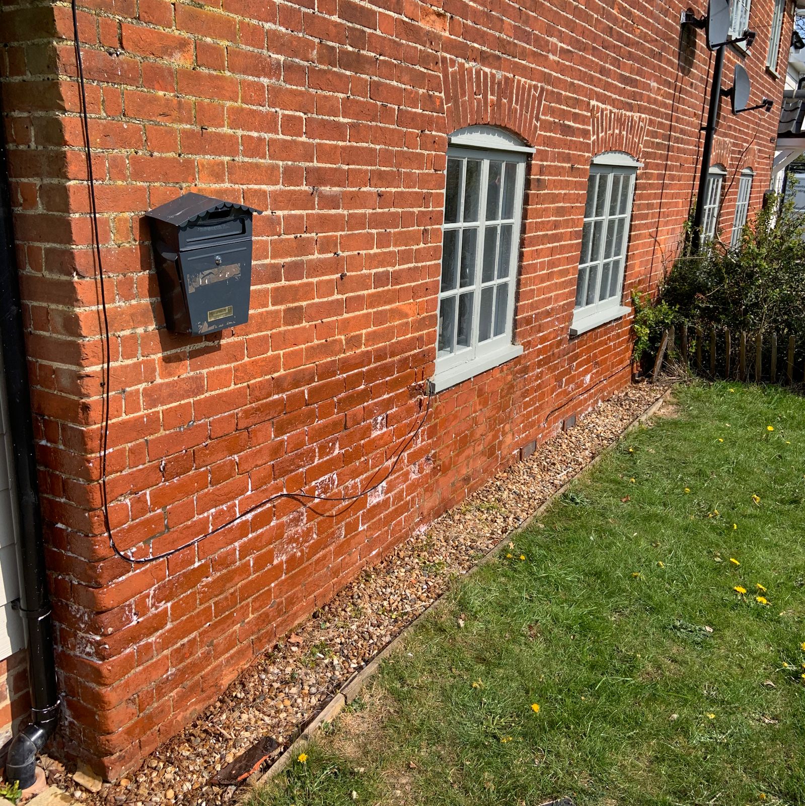 White salt staining low down on an old red brick wall