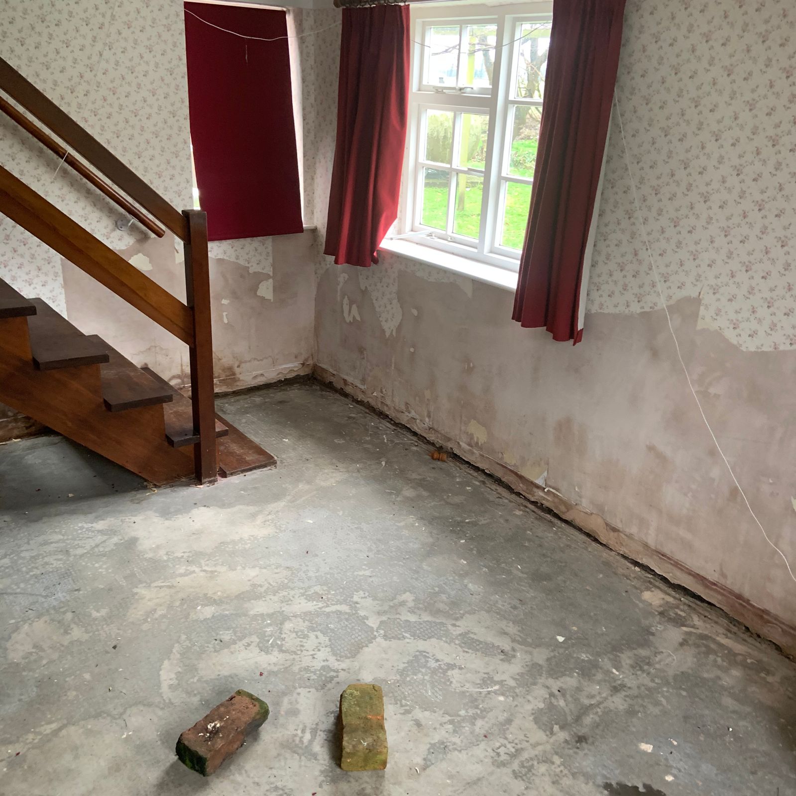 A cottage room with the lower walls stripped back during damp treatment